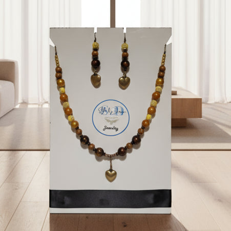 Jewelry set with beads and heart pendant on a white card with a brand logo.