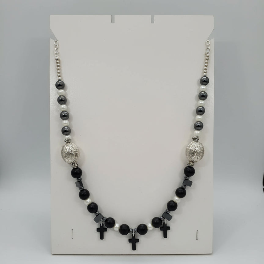 Necklace with black, white, and silver beads on a white card