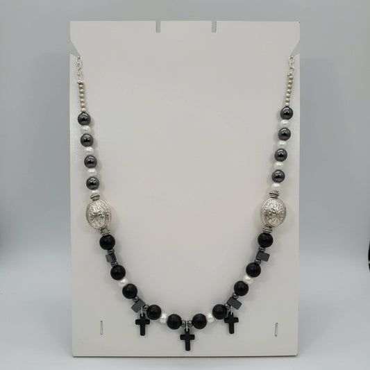 Necklace with black, white, and silver beads on a white card