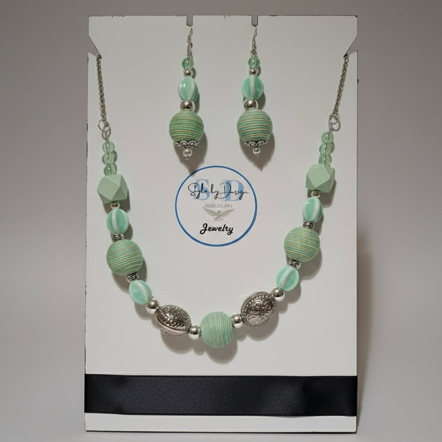 Necklace and earrings set on a display card with 'SbD Jewelry' logo.